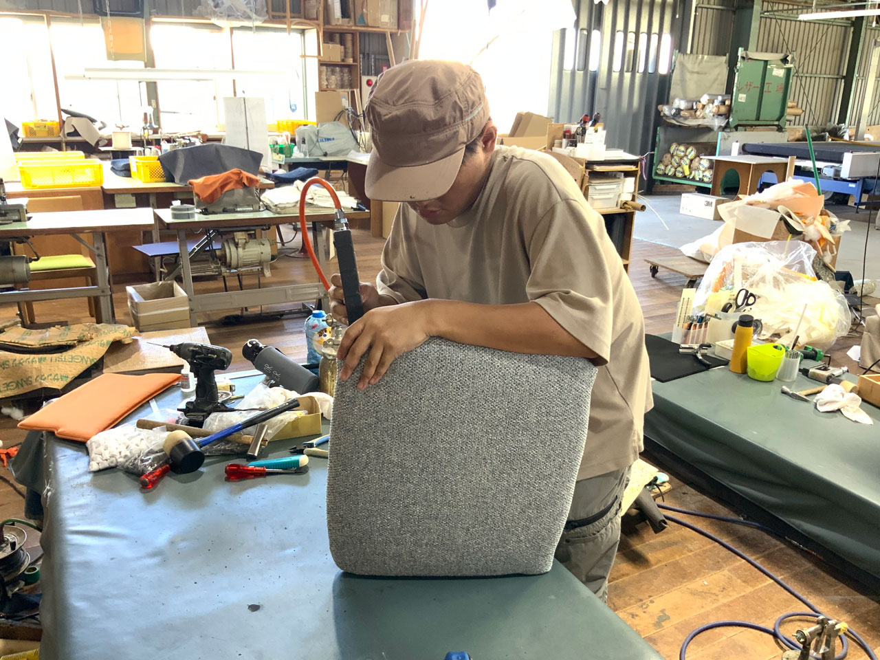 イストクの職人が木製の椅子に張地を張っている様子。