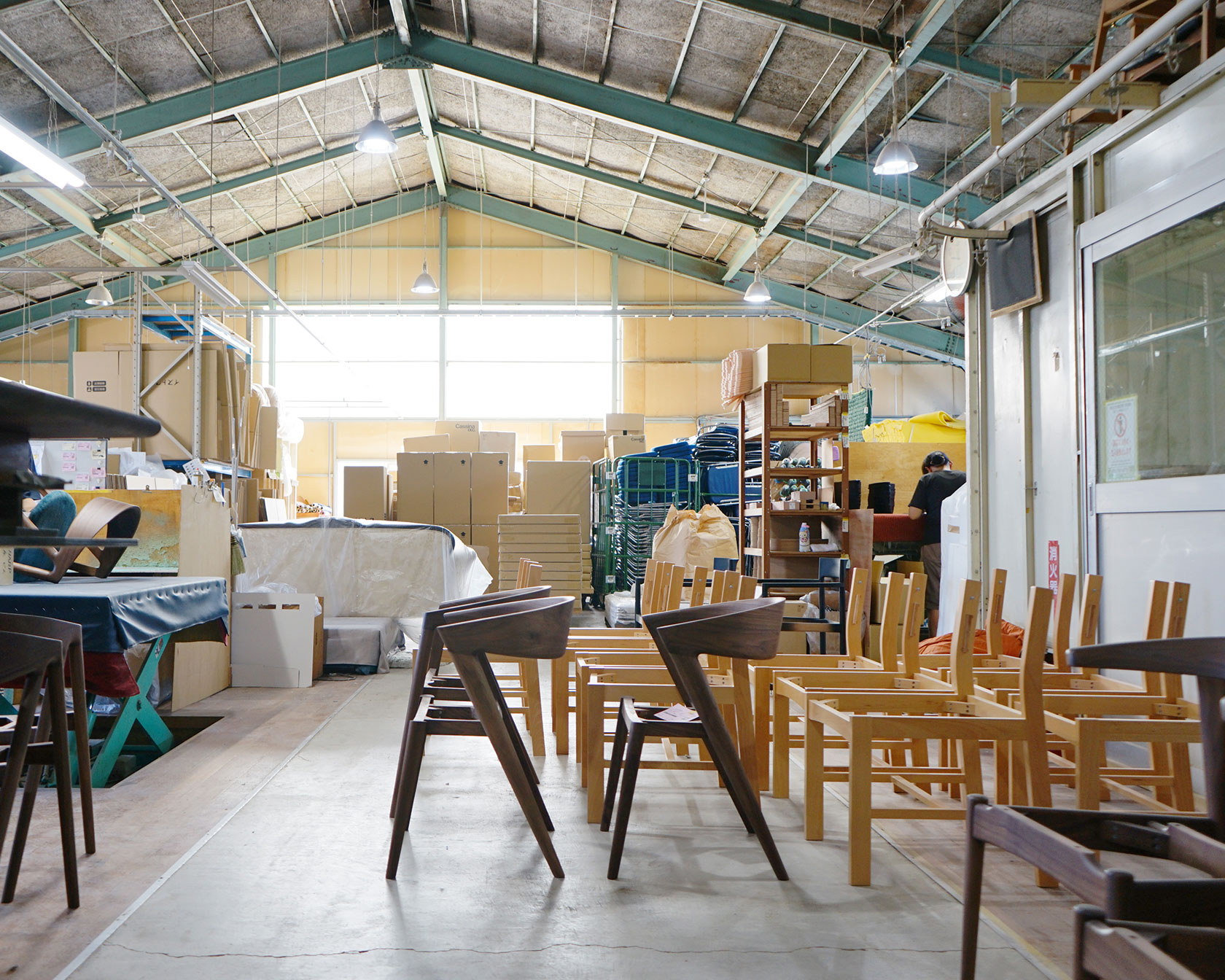椅子が並ぶイストクの工場内、木製椅子の製造現場と職人の作業風景