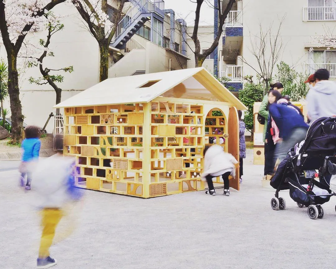 公園に設置された木製寄木細工の展示ハウス、人々が興味深く見学している様子