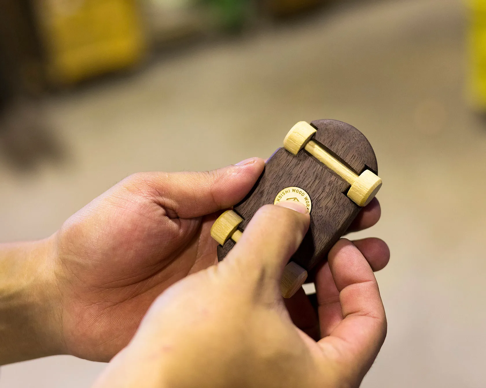 徳島の小石製作所で丁寧に仕上げられた木製ミニカーと底面のKOISHI WOOD WORKブランドマーク