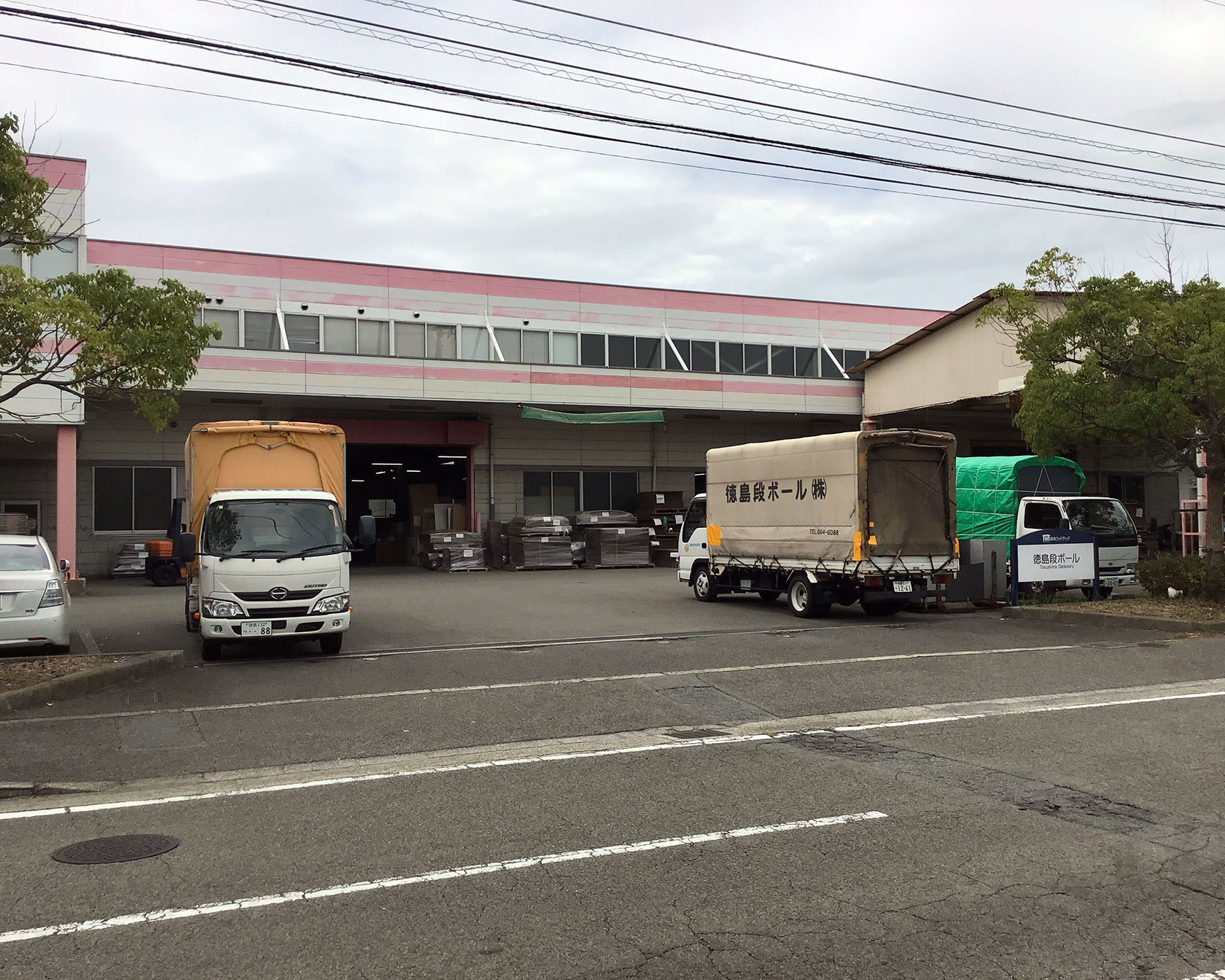 段ボール製造や配送拠点となる徳島段ボールの本社工場とトラックヤード